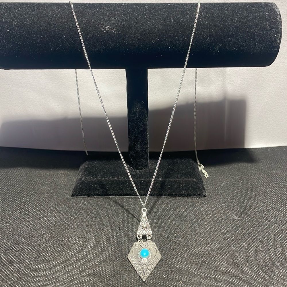 Long necklace with large metal pendent